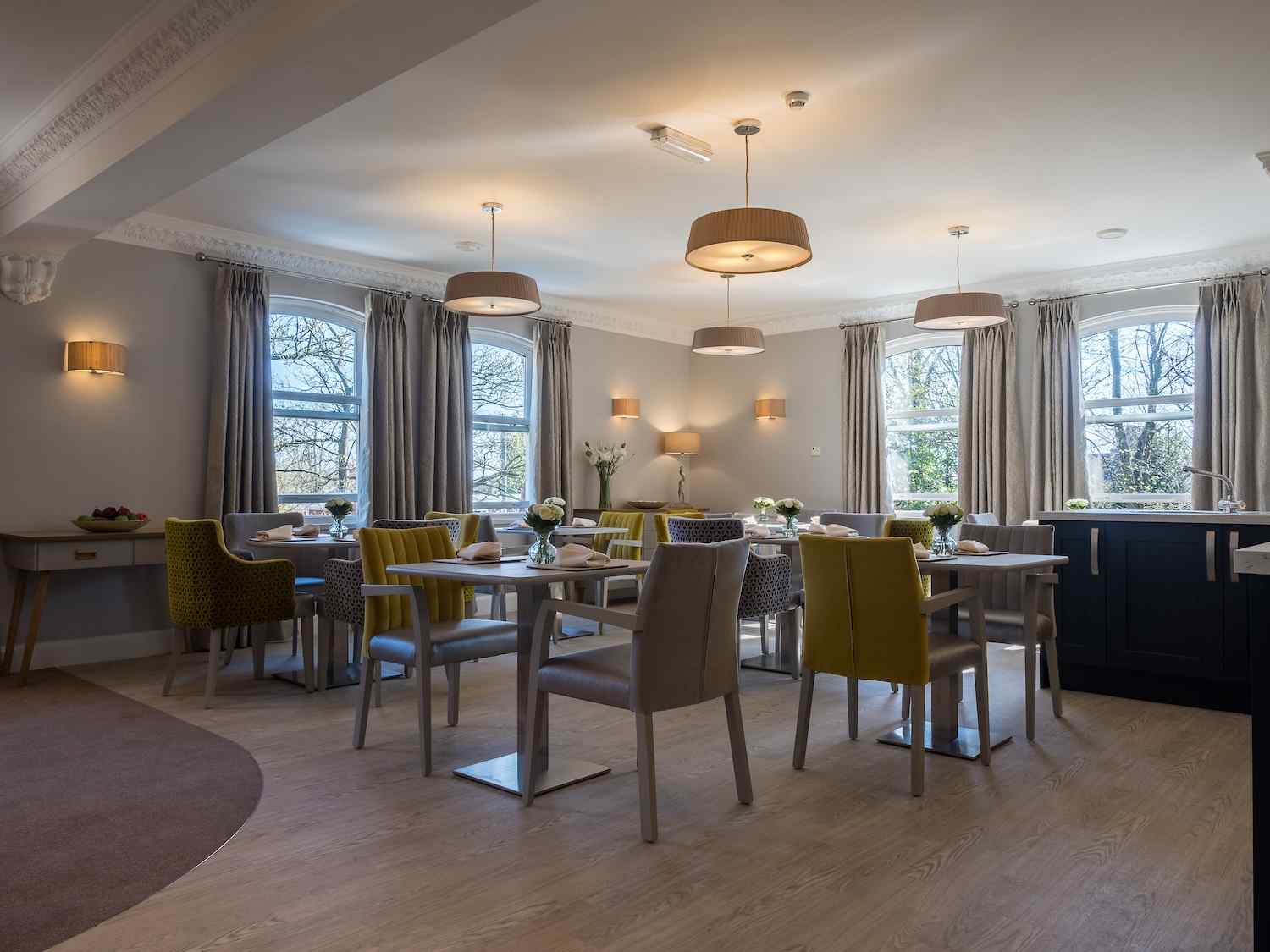 our dining room with yellow and grey chairs with flowers on the table