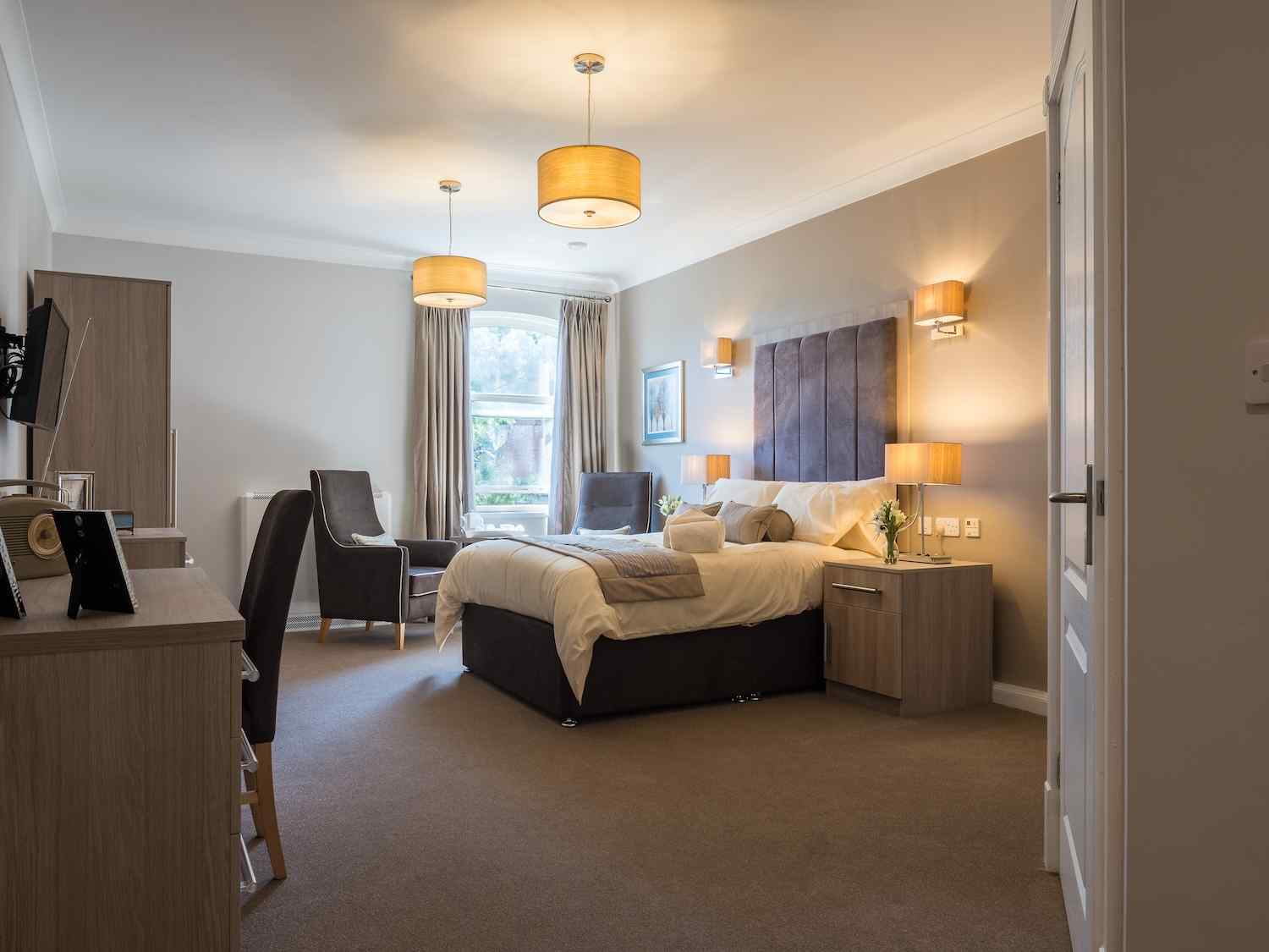 full view of our bedroom with a bed, 2 armchairs, storage space and a TV